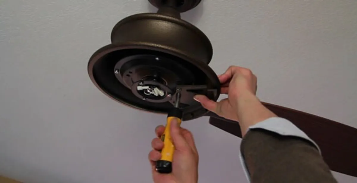 Electrician installing ceiling fan mounting bracket and fixture in Columbia, SC